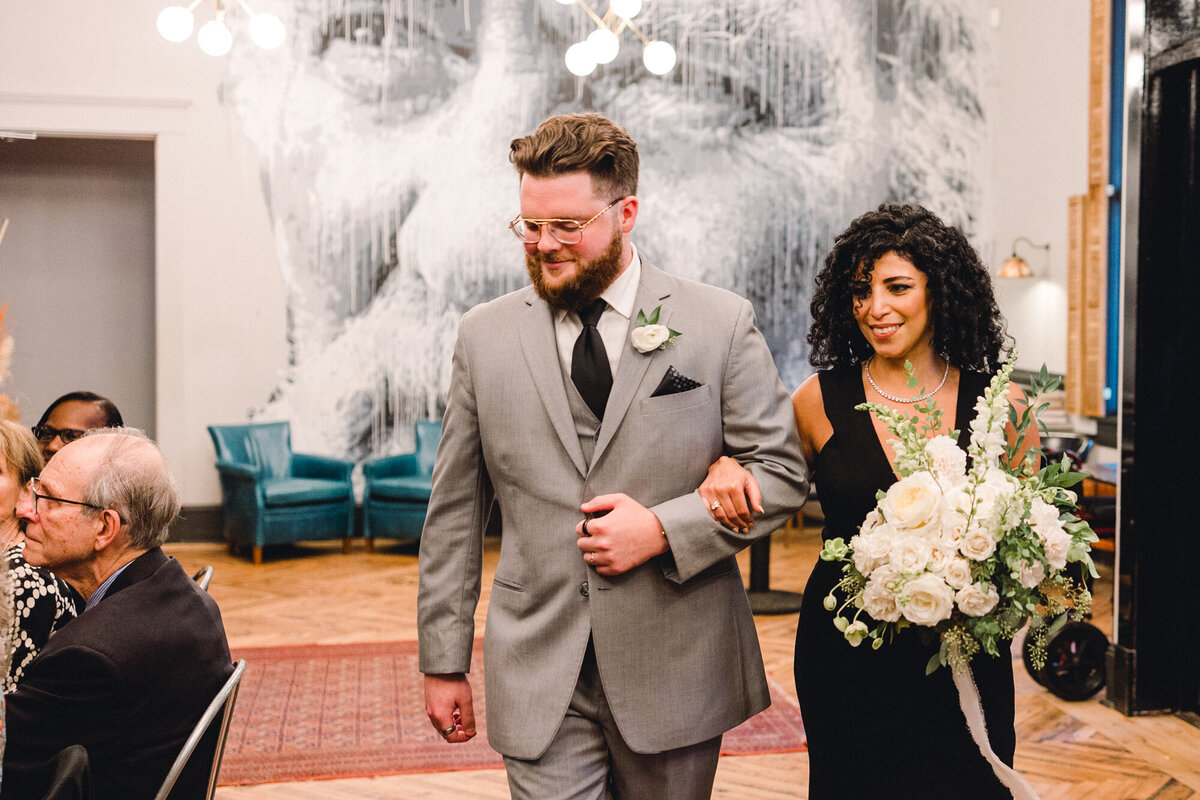 Bridesmaid and groomsmen walk across Vinegar Hall at Common House Charlottesville wedding