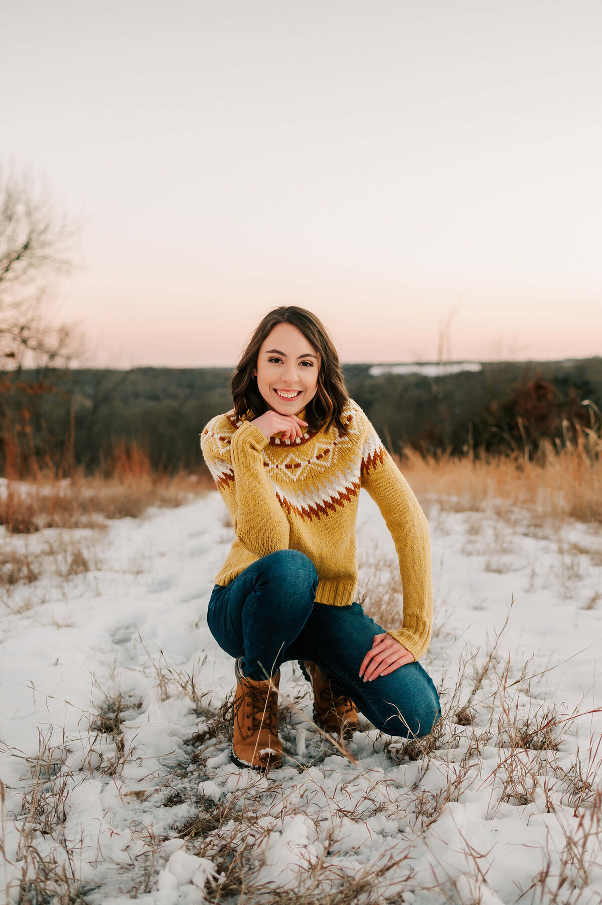 High school senior pictures of girl in yellow kneeling in snow in Springfield MO