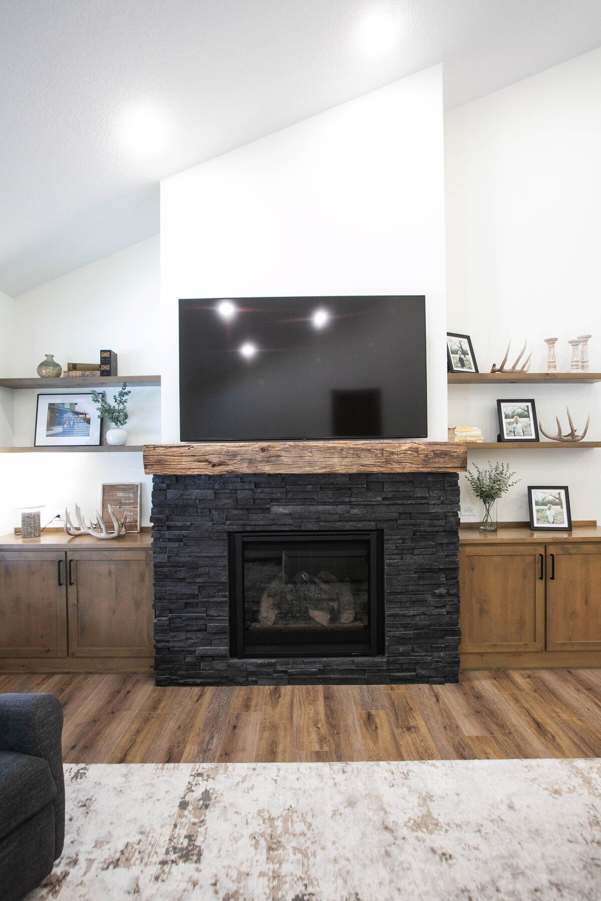 Cozy living room in Elk River custom home with fireplace, built-ins, and large windows