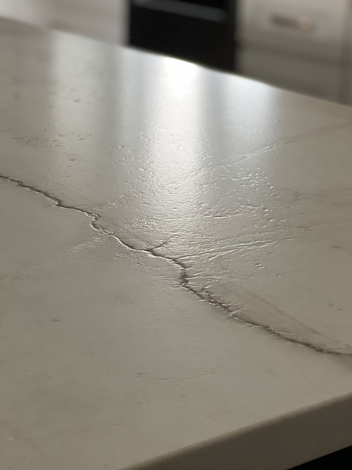 A white countertop shows deep veining and texture