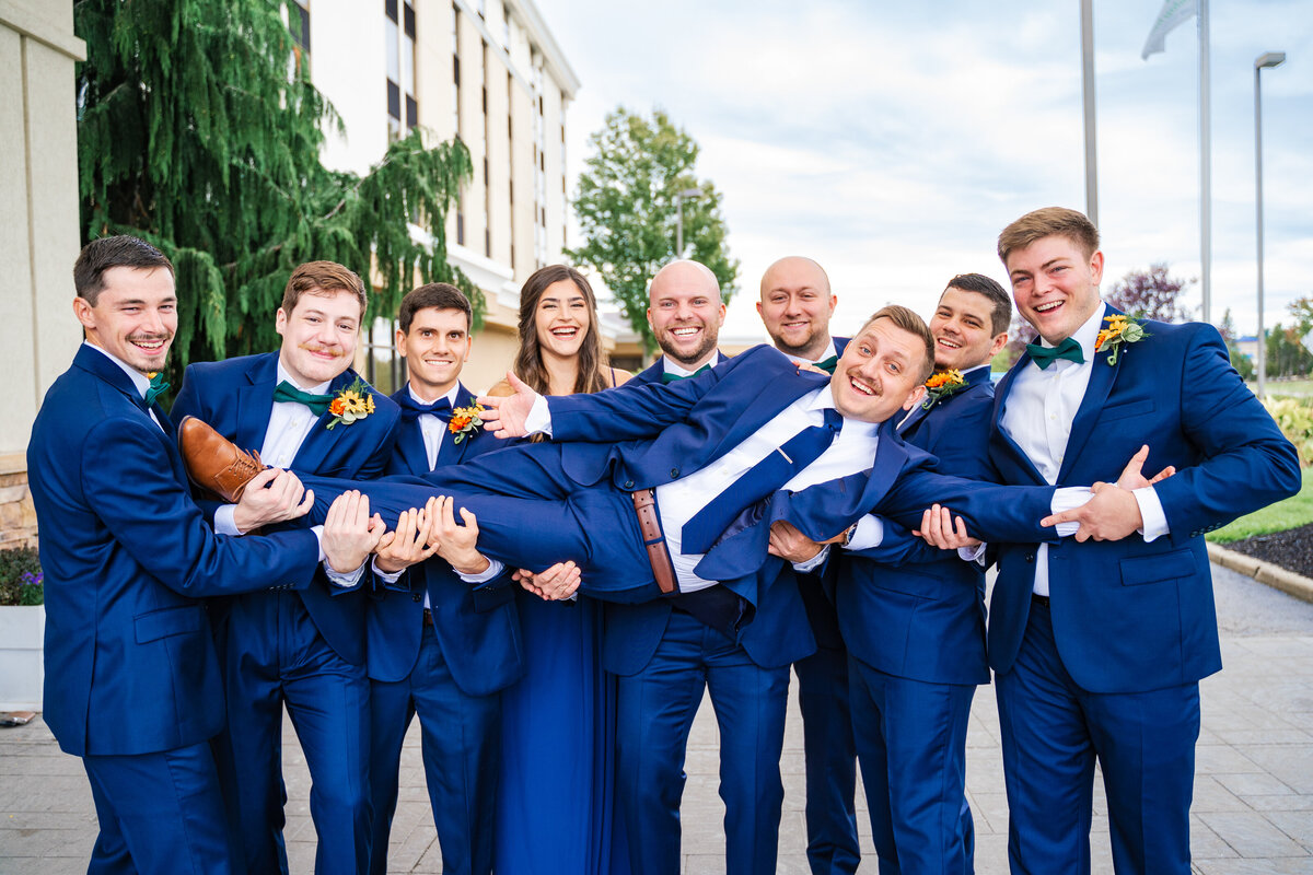 Groom laughs as his squad holds him up on his wedding day in Youngstown, Ohio.