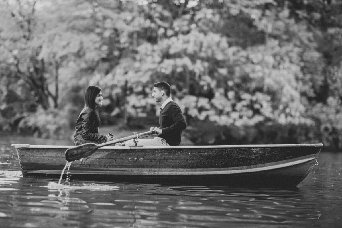 Couple sitting in boat in Central Park rowing on the lake.