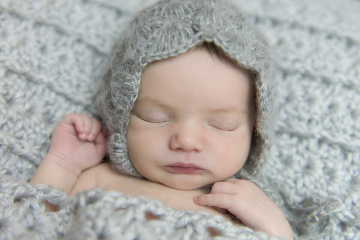 Newborn Baby girl in grey bonnet sleeping