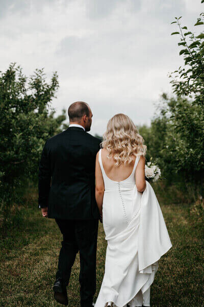 Bride and groom walking in bushes to show planning a wedding in chicago