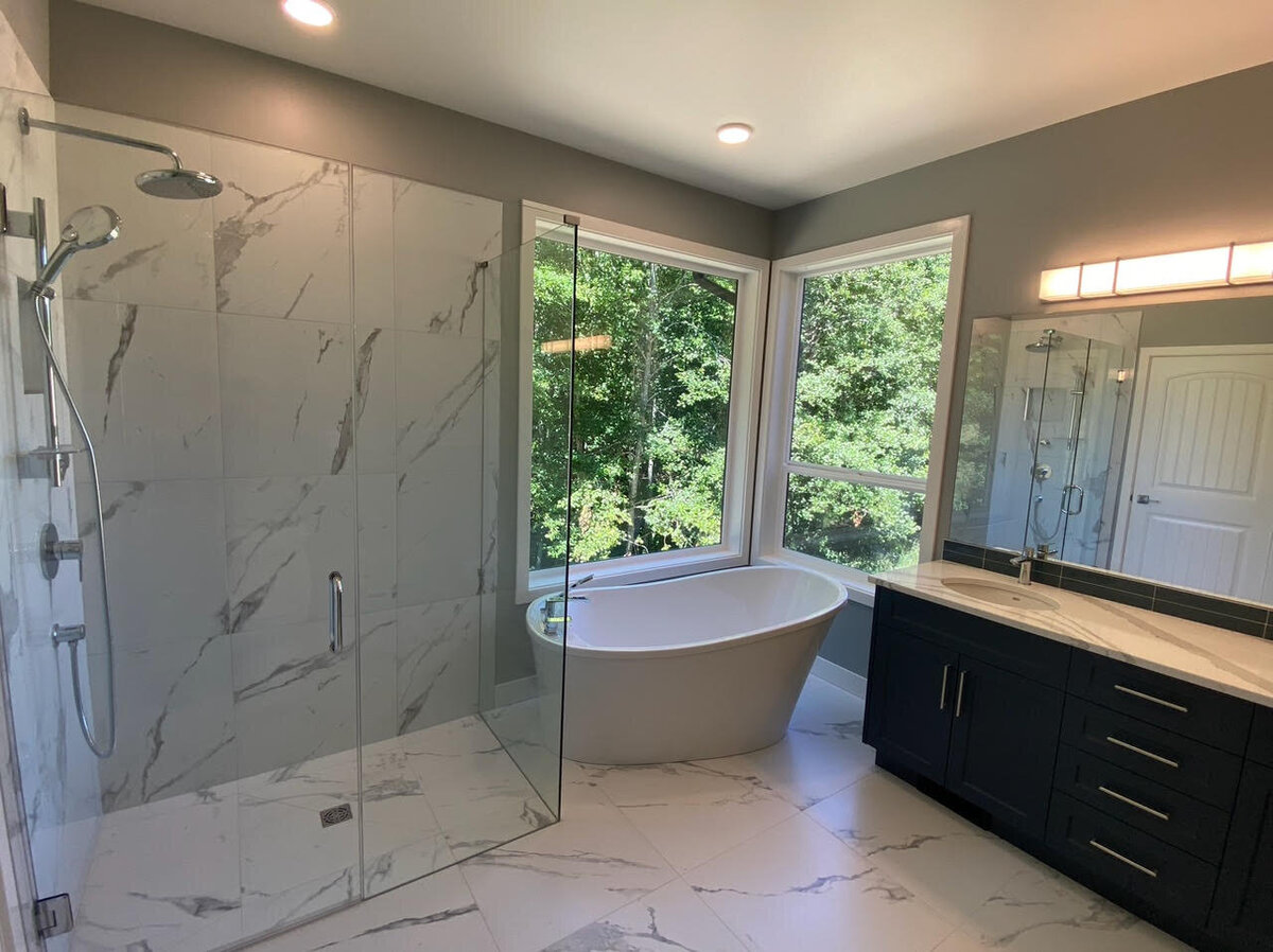 Modern bathroom design with angled freestanding bathtub, walk in shower, and white tiled flooring.
