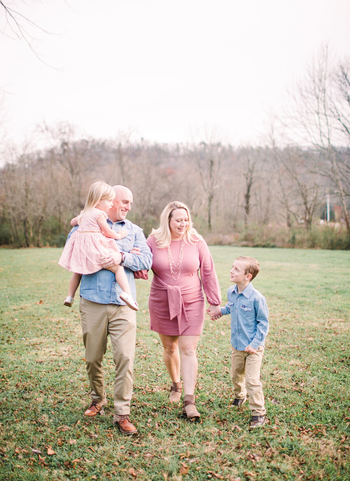 family walking together in a field for photos in Chattanooga