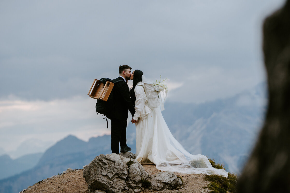 Couple kissing at picnic setup in front of Cinque Torri rocks