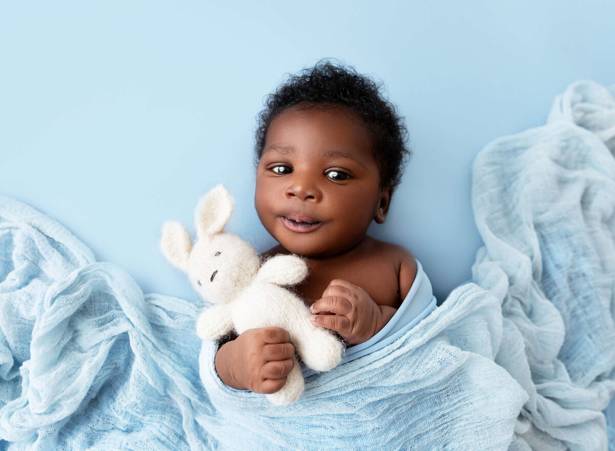 A posed newborn photo with soft neutral tones, taken at a Manhattan newborn photography studio NYC