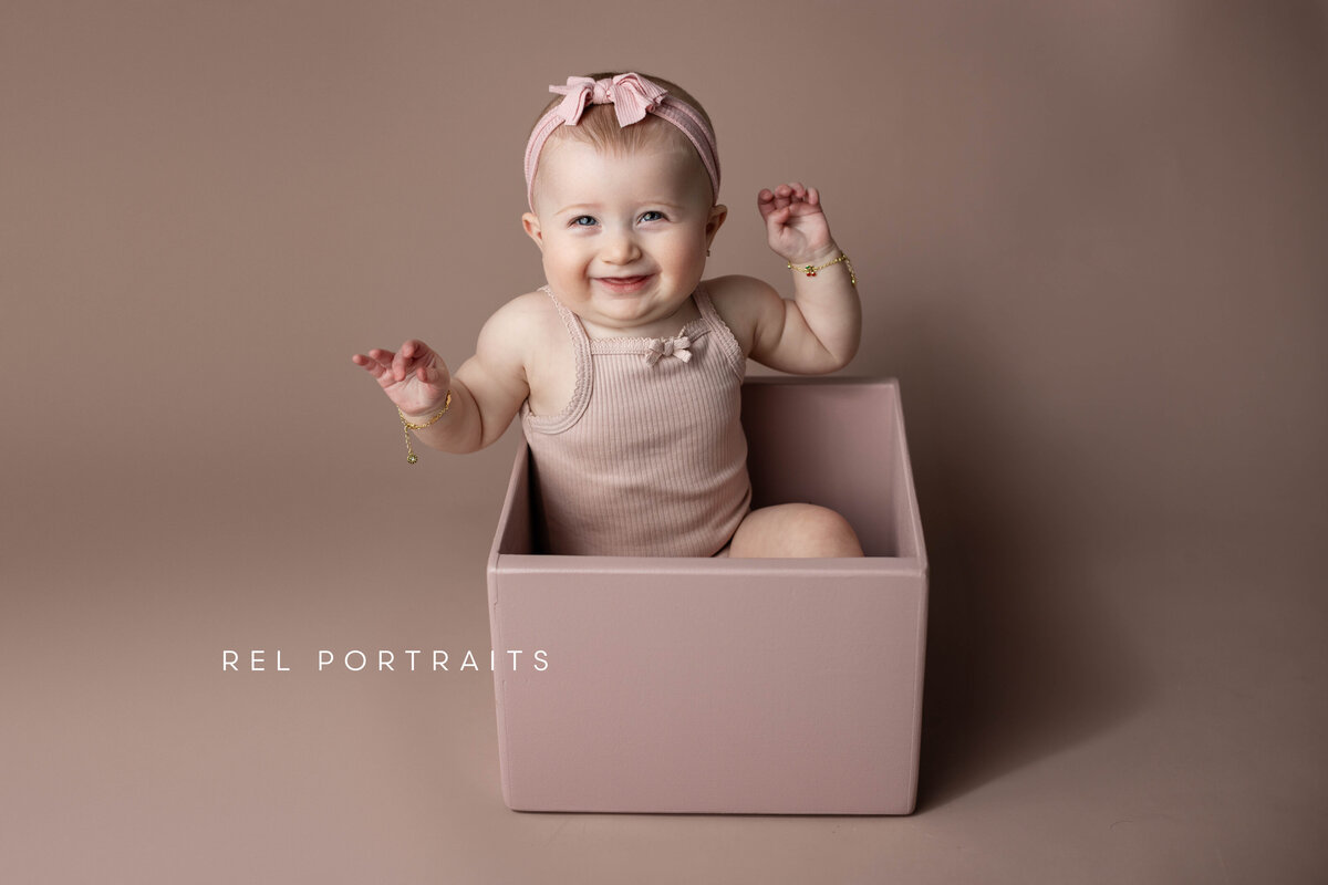 8 month baby girl in skokie in a box smiling