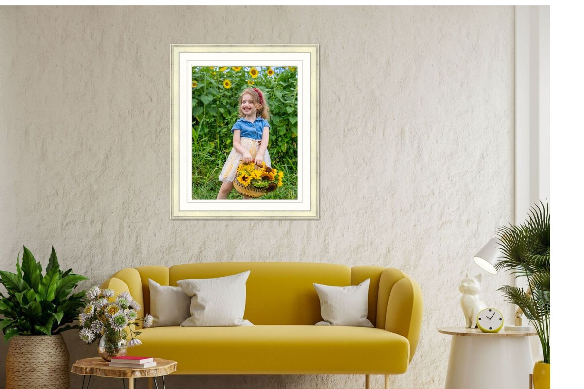 Gallery wall with four black-and-white family portraits framed above a living room sofa, designed and installed by Northern Virginia family photographer Capture Joy Photography.