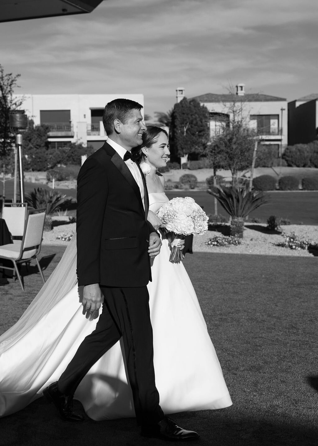 Bride walking with father during wedding ceremony entrance at Arizona Biltmore Golf Club.
