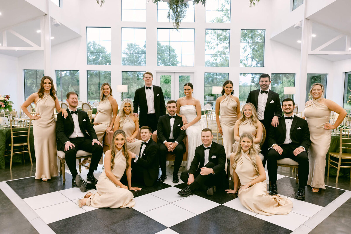 A wedding day photo of the the bride and groom with their bridal party posing for a group photo