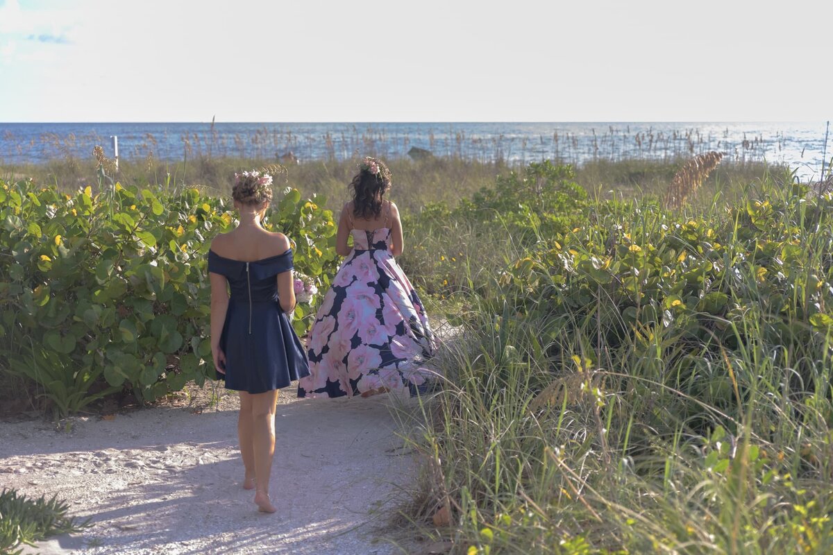 Bride and daughter walking to beach