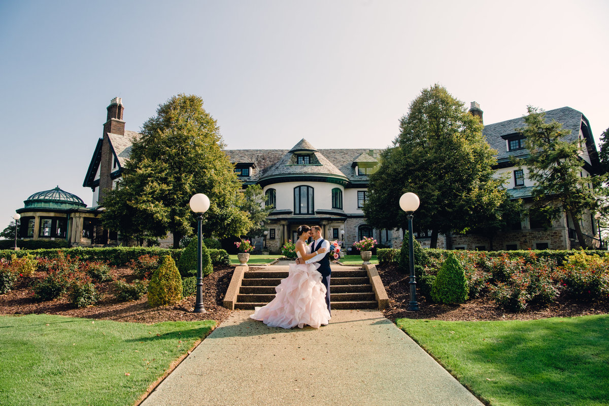 bride and groom hug in front of steps at linden hall