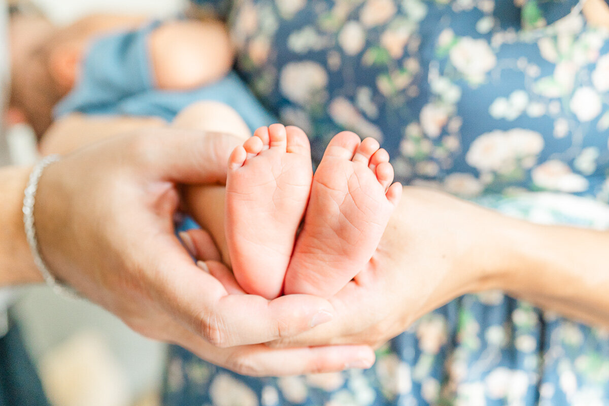 close-up photo of a newborn's feet held by his parents' hands during their lifestyle newborn session in Leander, TX.