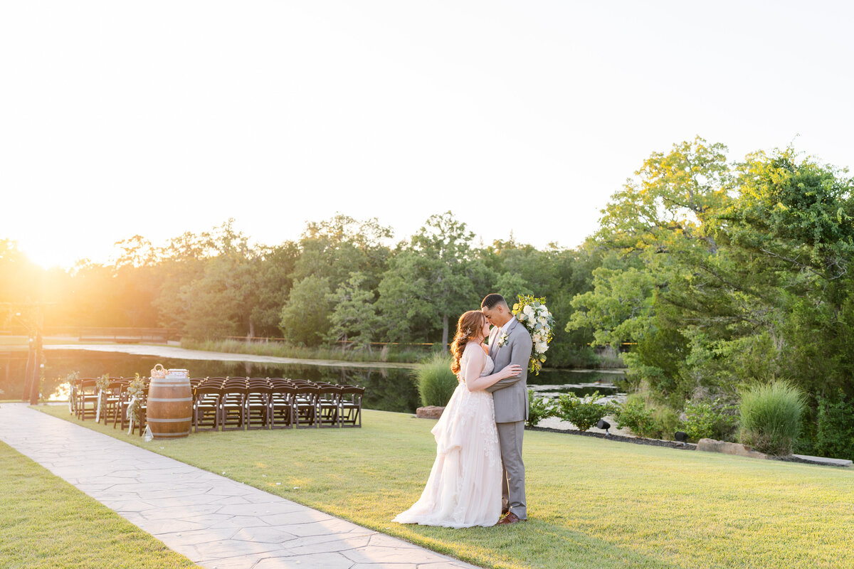 Bride and Groom forehead to forehead during golden hour sunset with lake and ceremony site behind them at Peach Creek Ranch