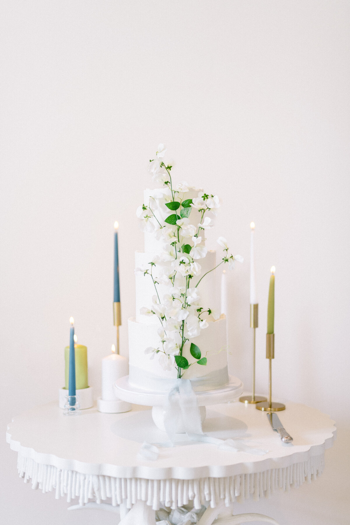 White wedding cake with sweet peas and silk ribbon