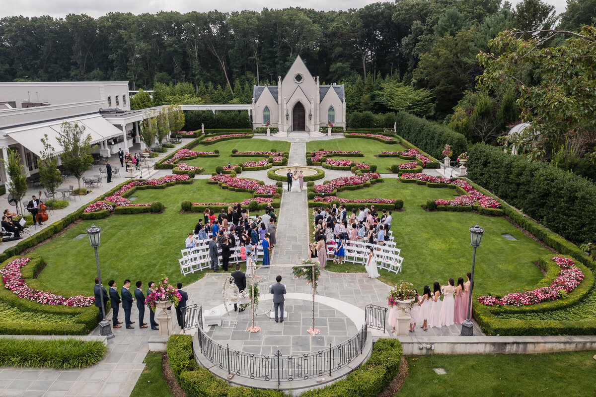 Wide angle view of a garden wedding ceremony at Park Chateau Estate and Gardens in New Jersey.