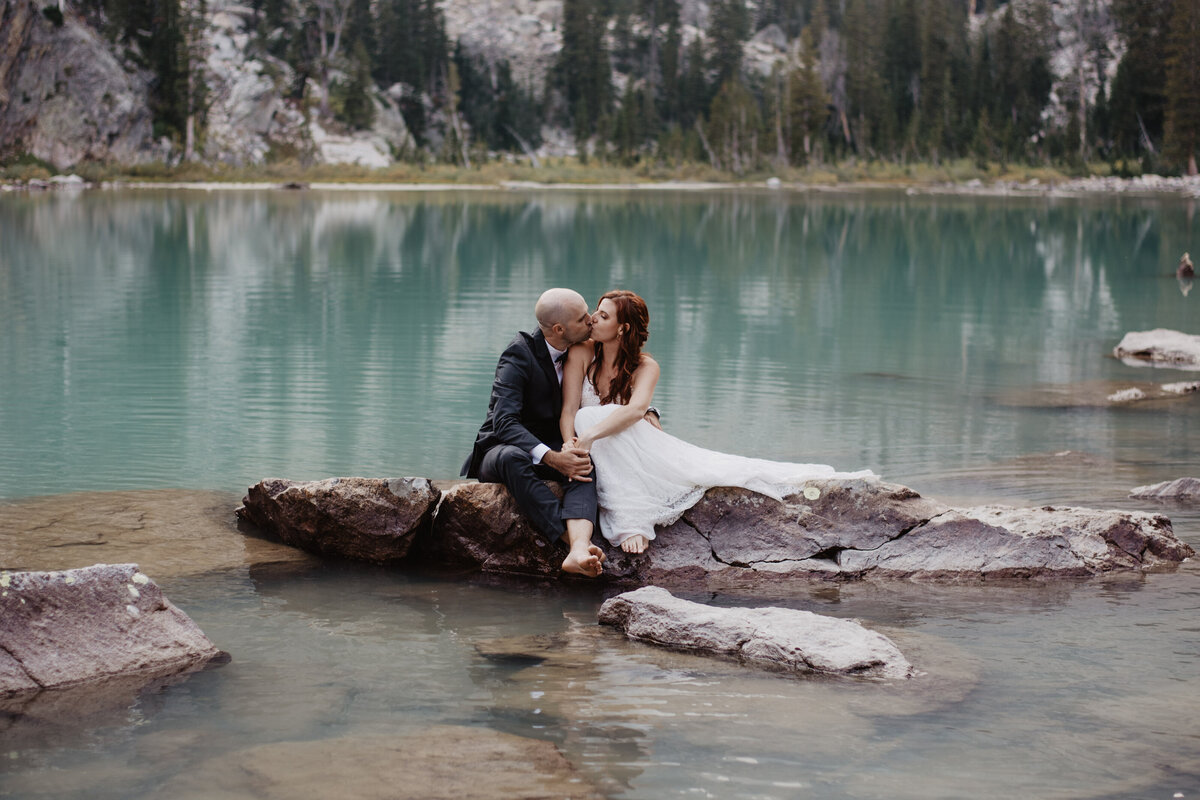 Jackson Hole Photographers capture bride and groom snuggling on rock