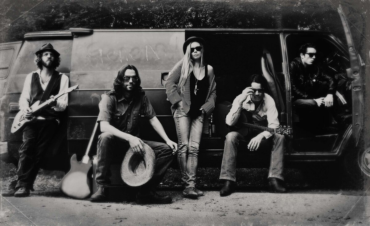 Musical band portrait black and white The Dustin Bentall Outfit sitting against old van with instruments
