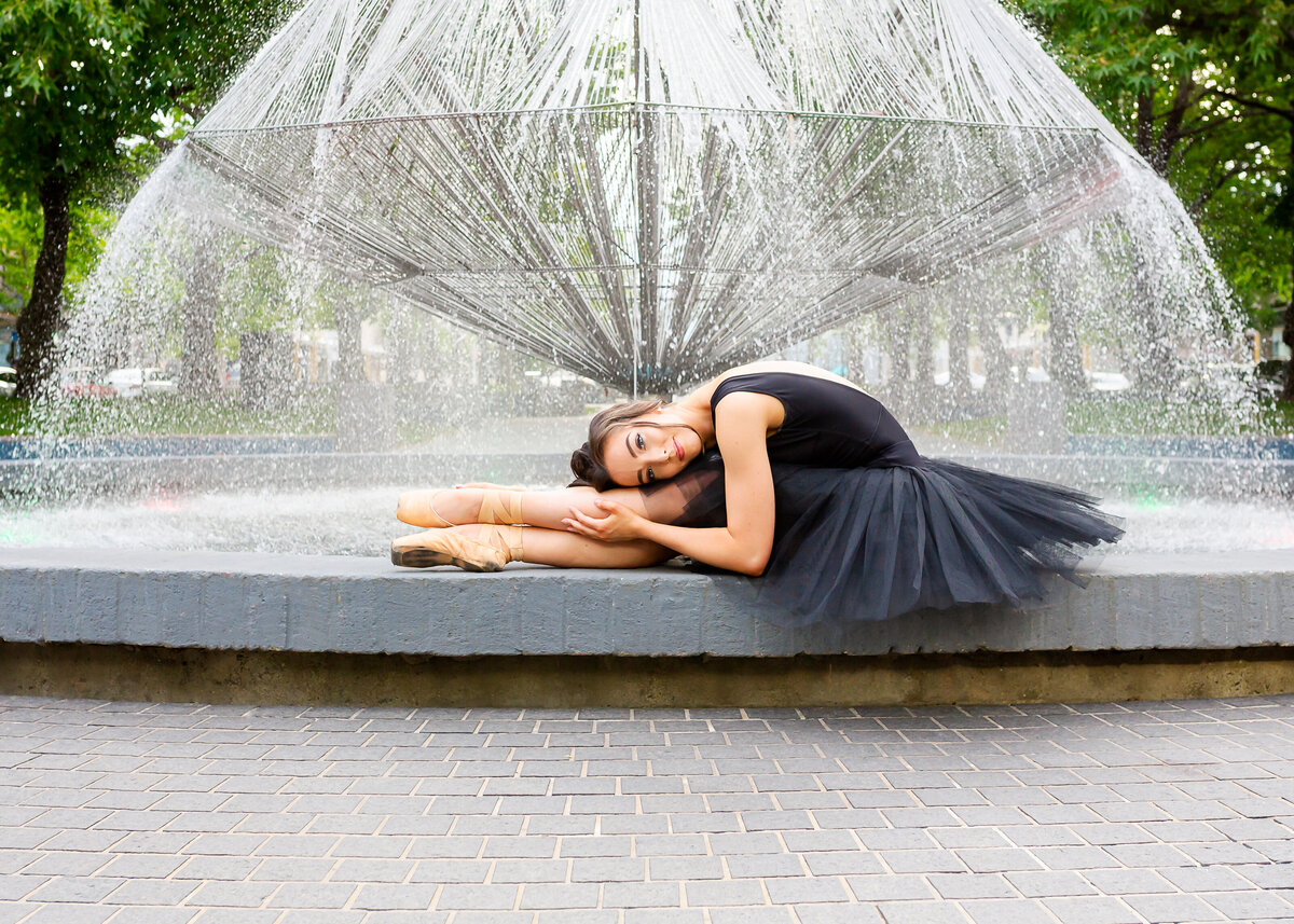 Dancer in tutu lying next to Canberra water fountain