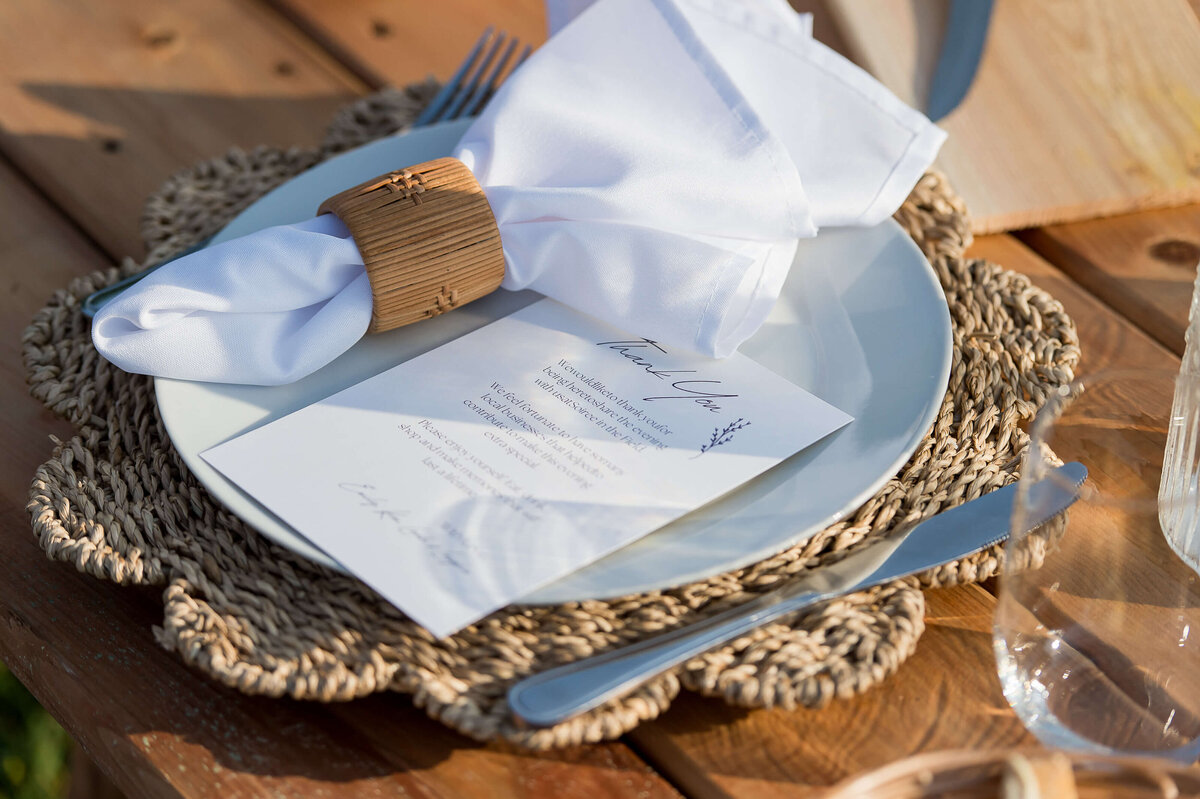 closeup photo of the individual place setting for Soiree in the Field showing the napkin, napkin holder, menu, charger plate and cutlery.  Captured by Ottawa Event Photographer JEMMAN Photography COMMERCIAL