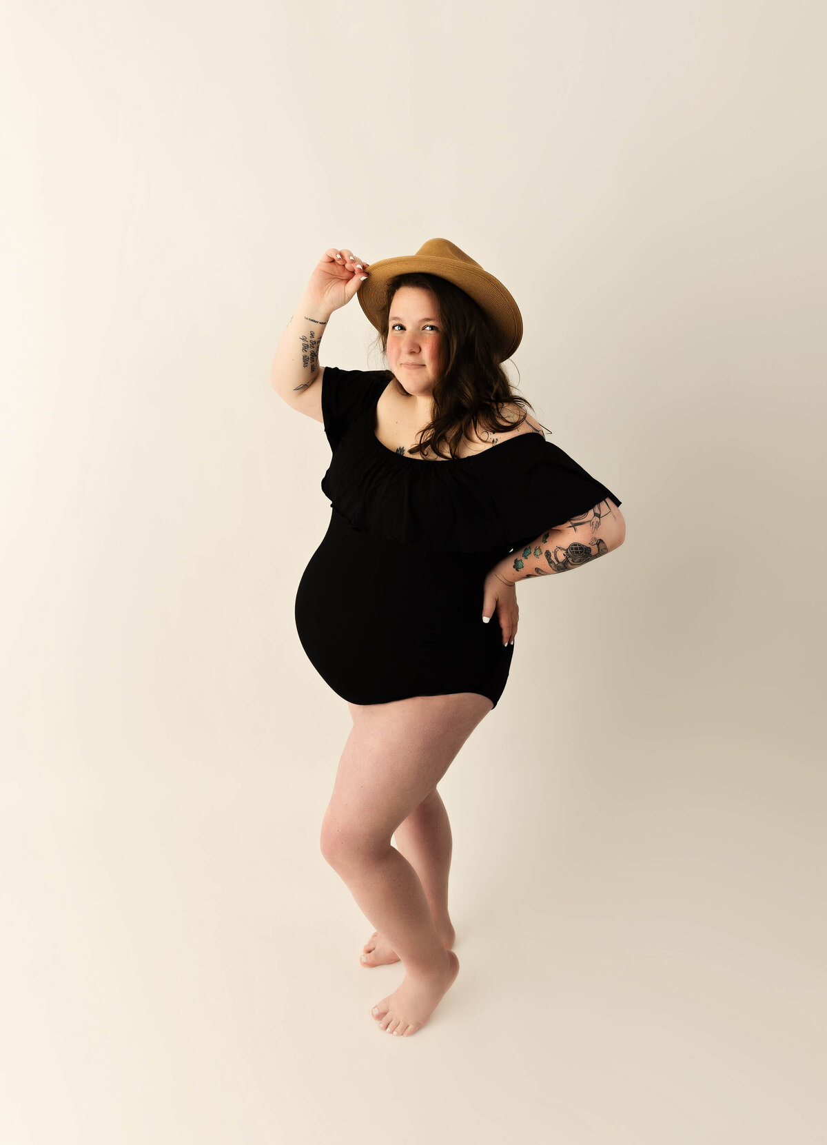 Maternity photo of a girl in a black body suit with a hat in an Erie PA studio