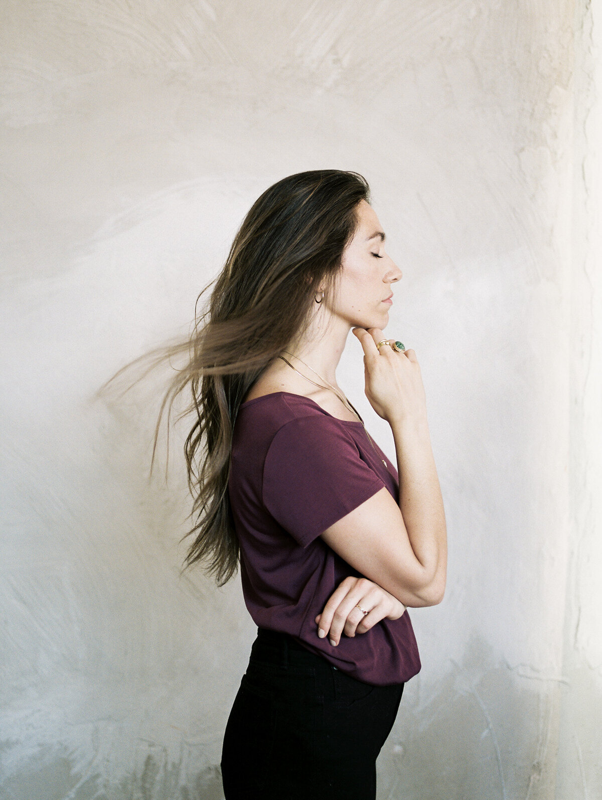 woman with wind in her dark hair, peaceful look, painterly background