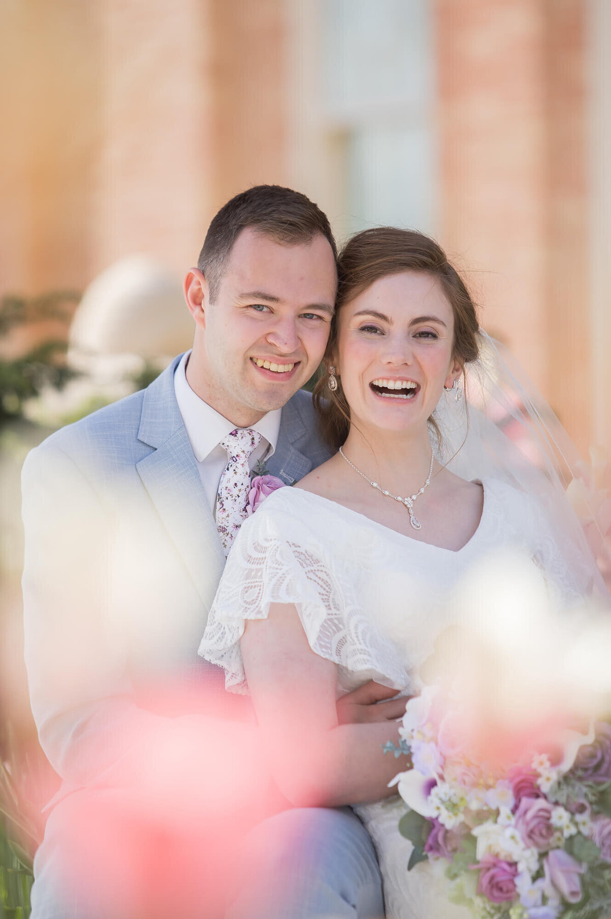 a wedding couple laughing in a garden