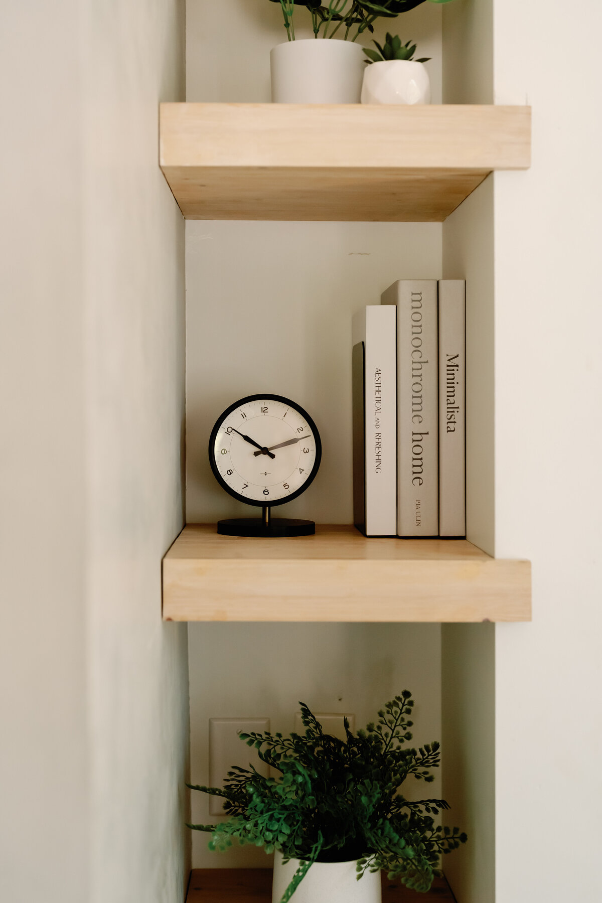 light wood bookshelf in concrete wall