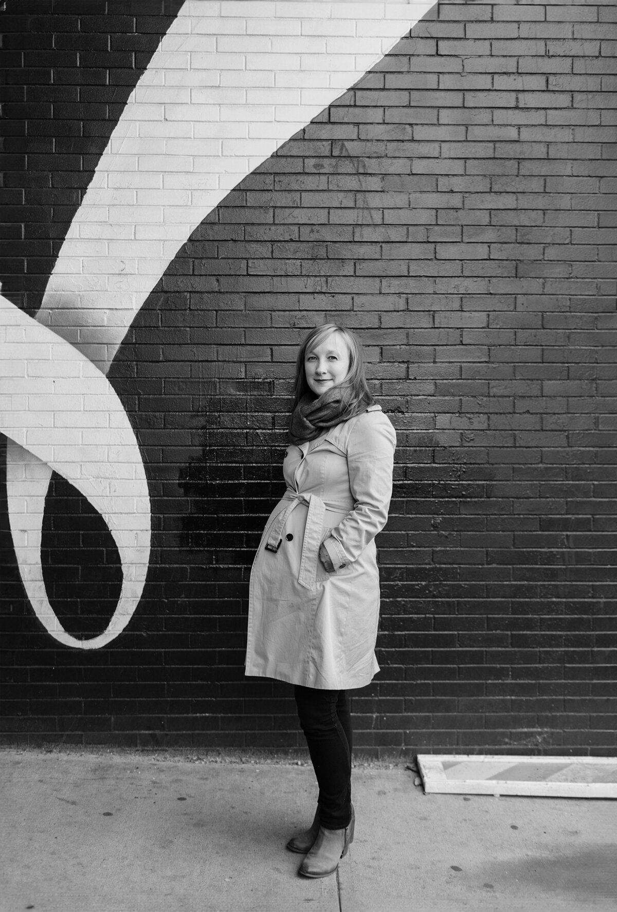 Pregnant woman poses in trench coat in Brooklyn.