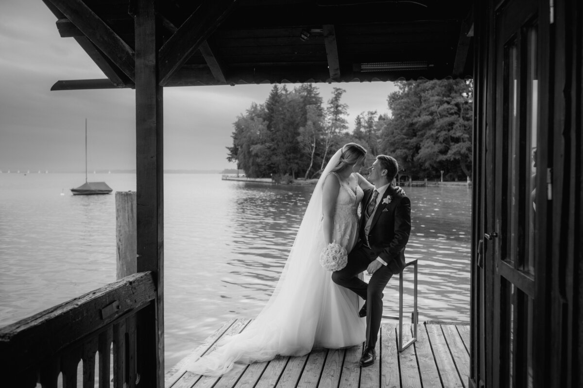 Black and white view of the wedding couple looking each other deep in the eyes at a lake house.