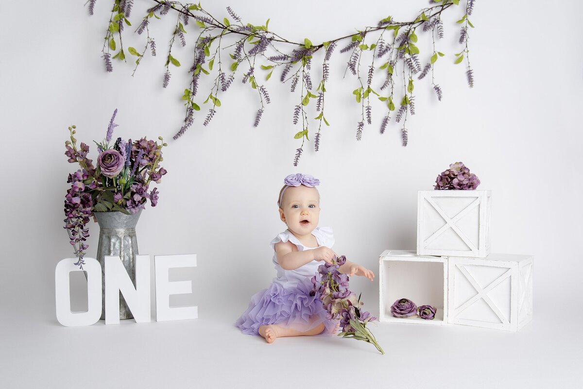 Palm Beach Cake Smash Photographer captures one year old in purple background.