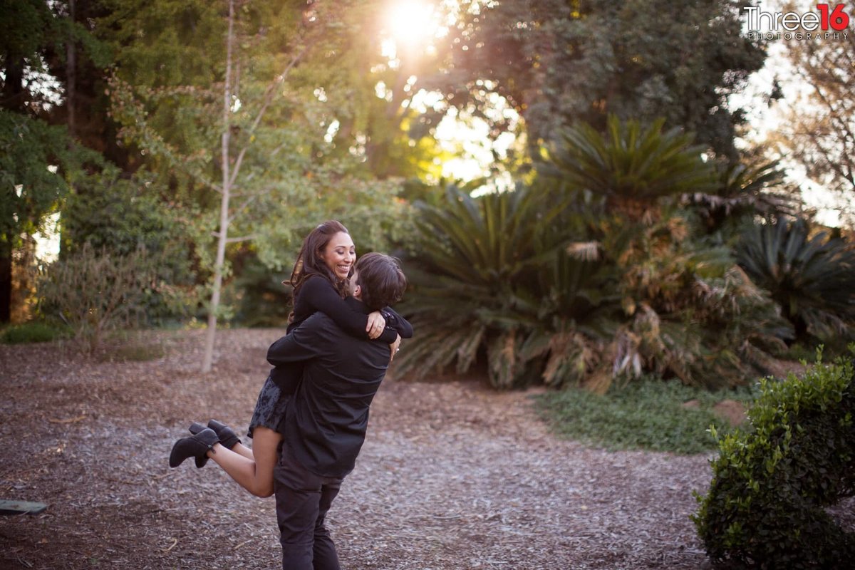 Bride to be jumps in her Groom's arms with a big smile on her face