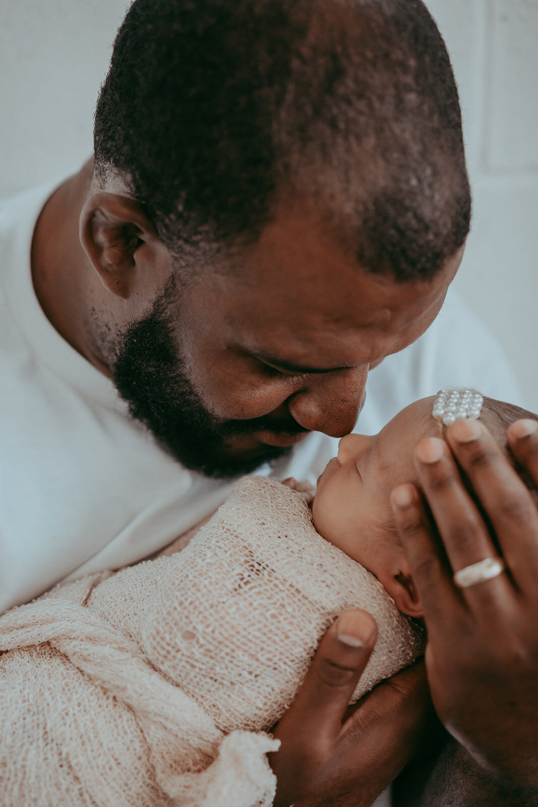 dad nuzzles noses with his newborn baby