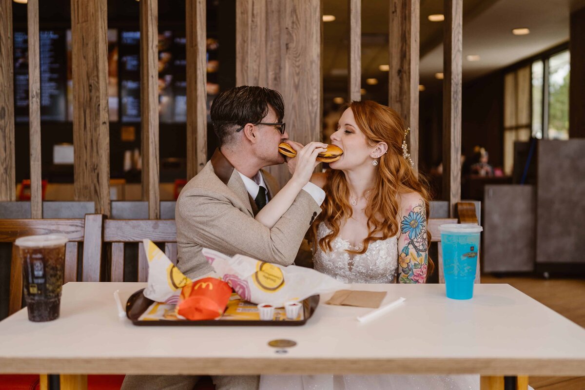 Bride and groom share cheeseburgers at a McDonald’s after their Rocky Mountain National Park elopement.