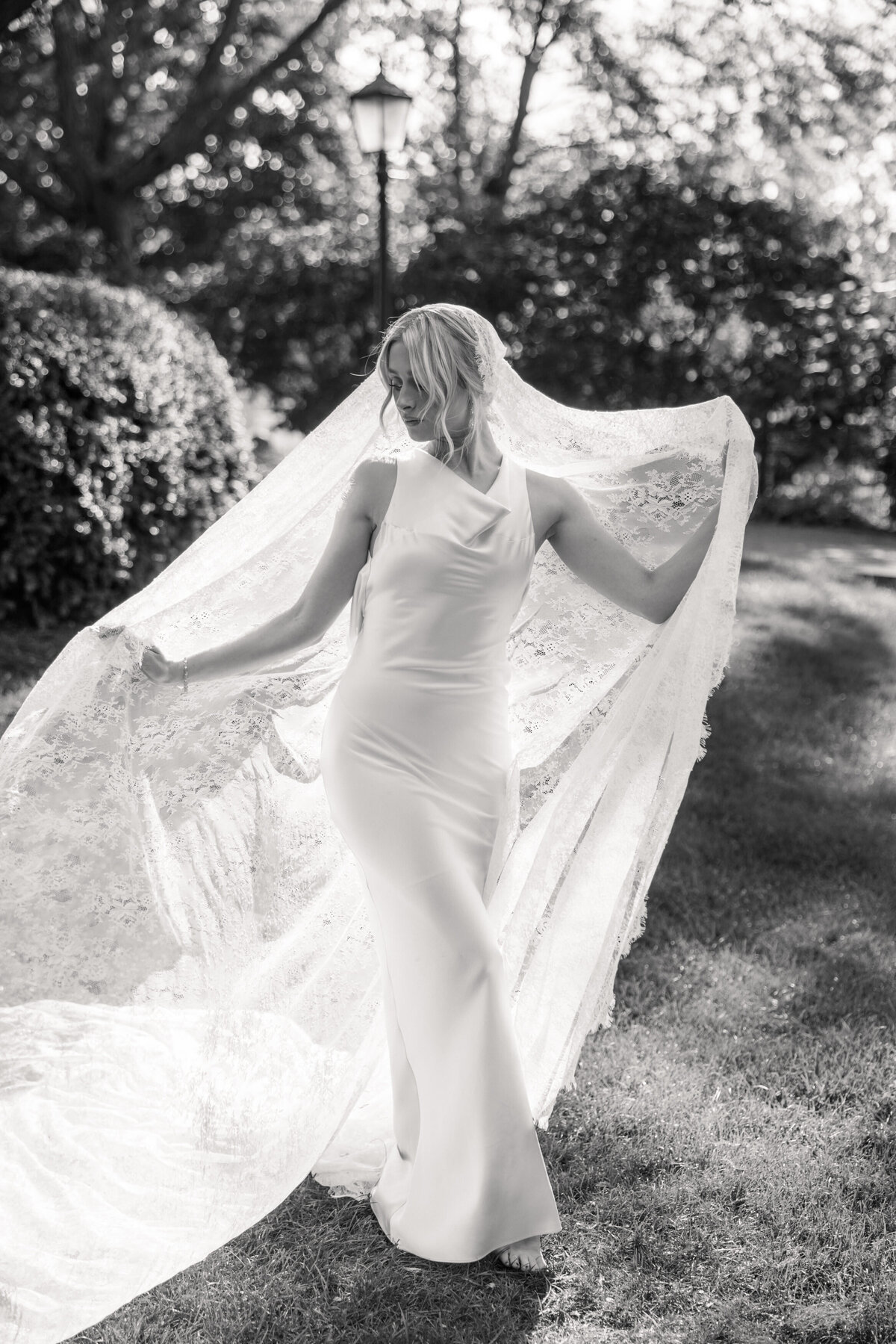 Bride poses with lace veil spread, captured at Dayton, Ohio wedding by Philadelphia wedding photographer.