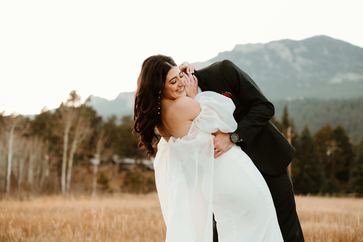 Groom Dipping Bride in Mountain Field