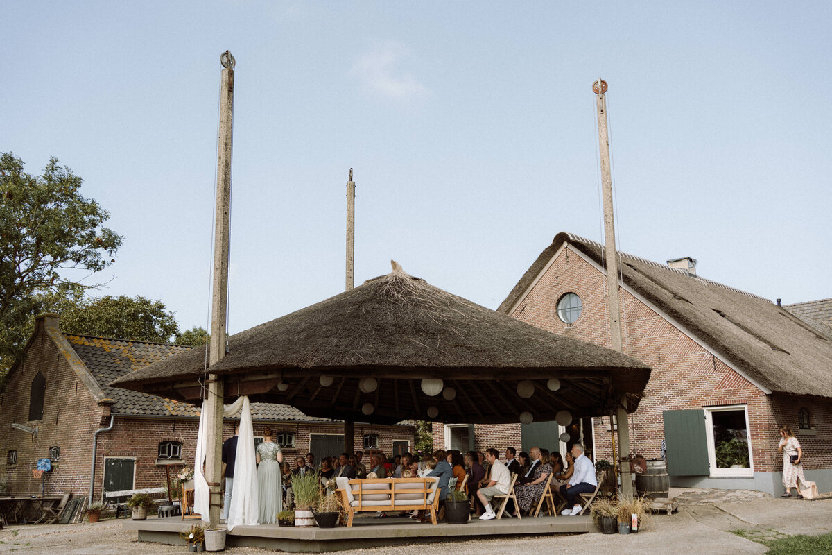 Sfeervolle bruiloft bij Nigtevecht Freeland Farm, met een persoonlijk aangekleed decor en het bruidspaar dat geniet van een lange borrel in een gezellige, intieme sfeer. Sfeerbeeld van de ceremonie. 