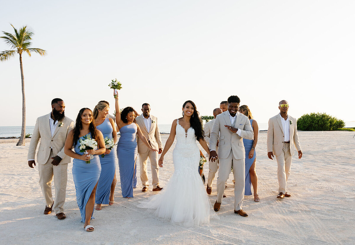 The newlyweds lead their stylish bridal party along the pristine coastline at Table Key, Islamorada, in a stunning golden-hour moment. Captured by Claudia Amalia, destination wedding photographer.