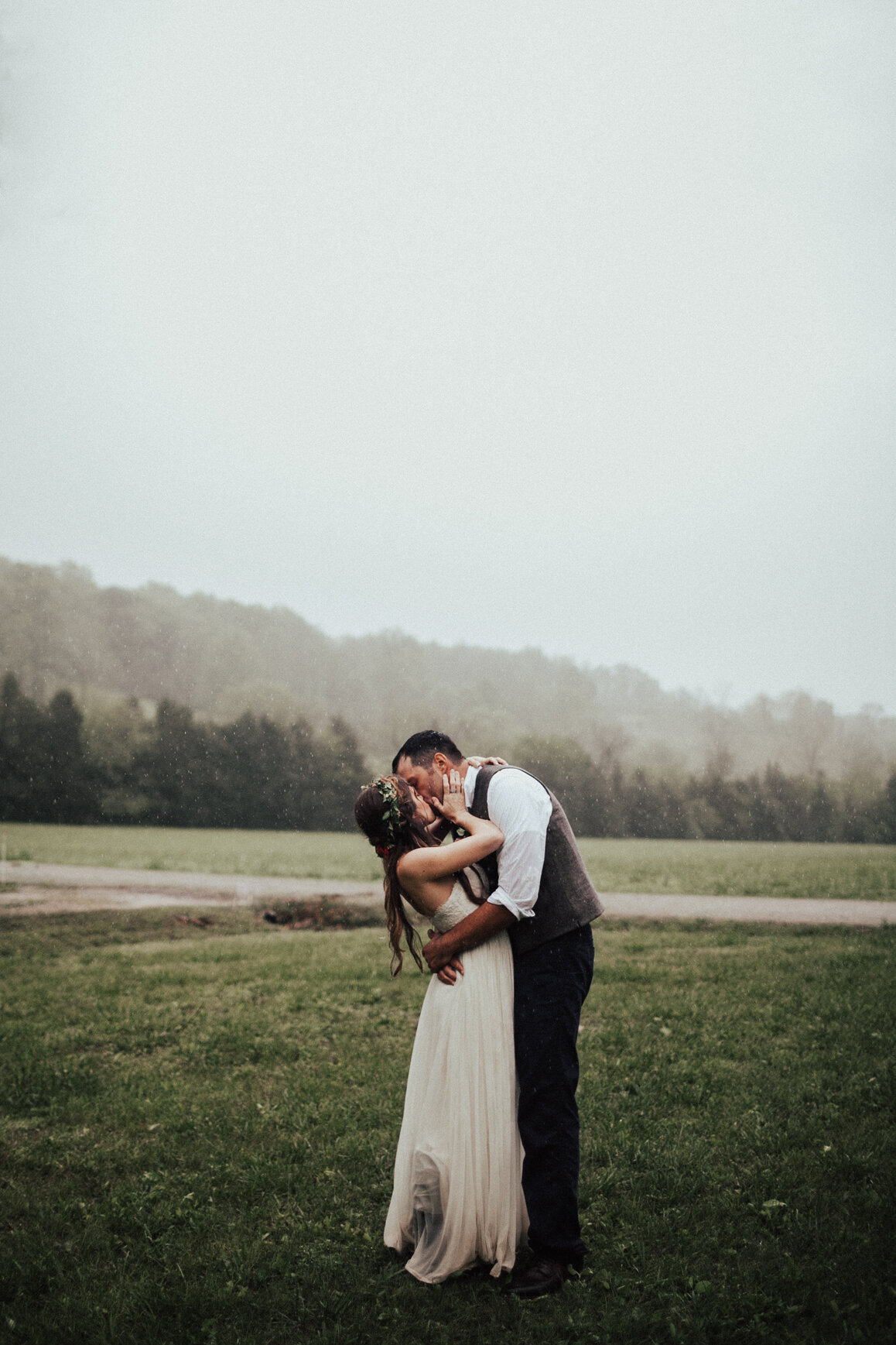 bride and groom couple kissing in the rain