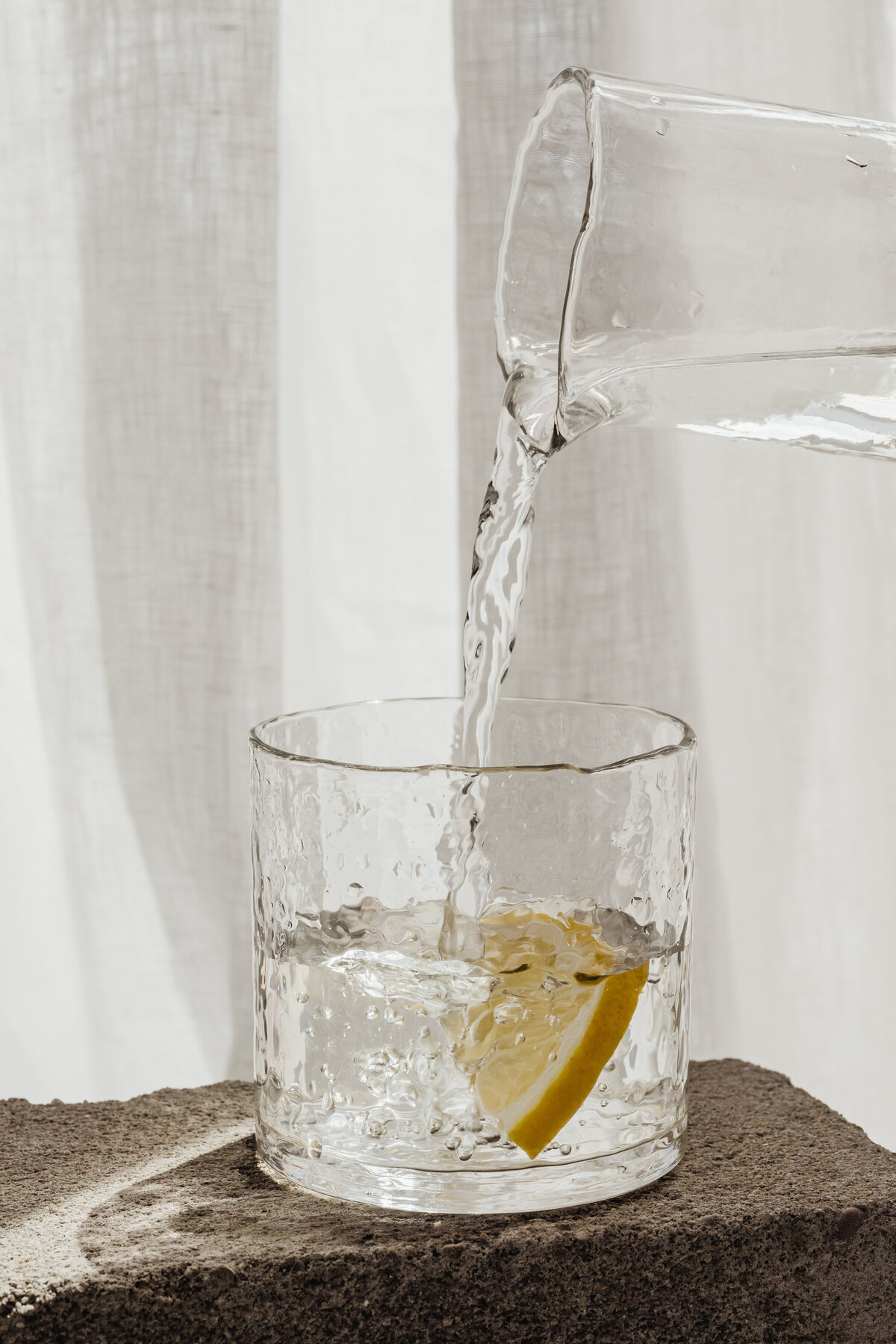 kaboompics_lemon-slice-in-a-glass-of-water-pouring-26581