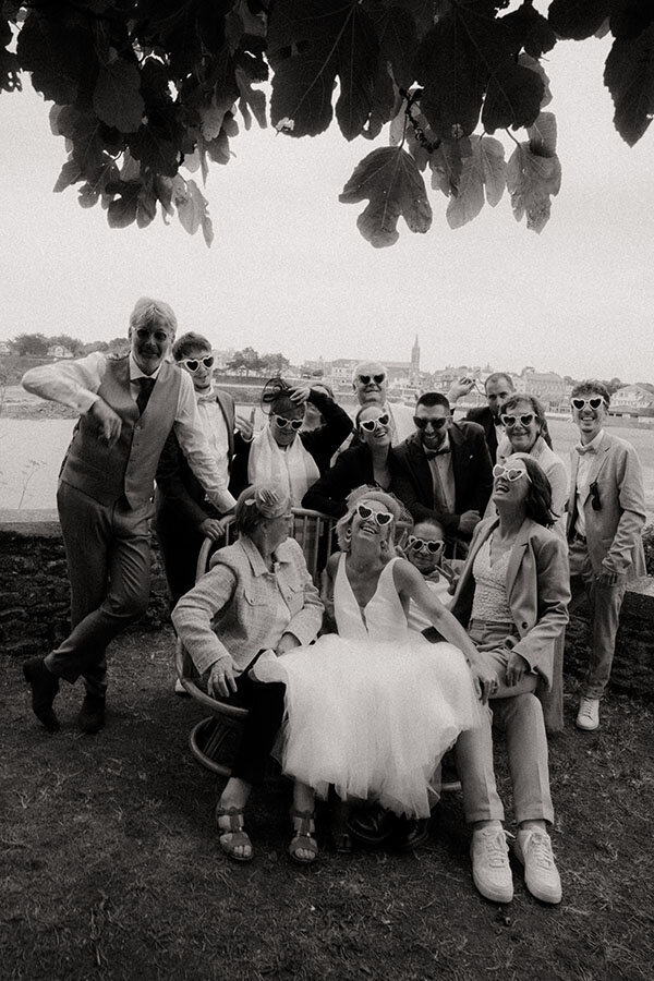 Photo de groupe en noir et blanc, ambiance fun et décontractée, lors d'un mariage en Bretagne capturé par kamescop.