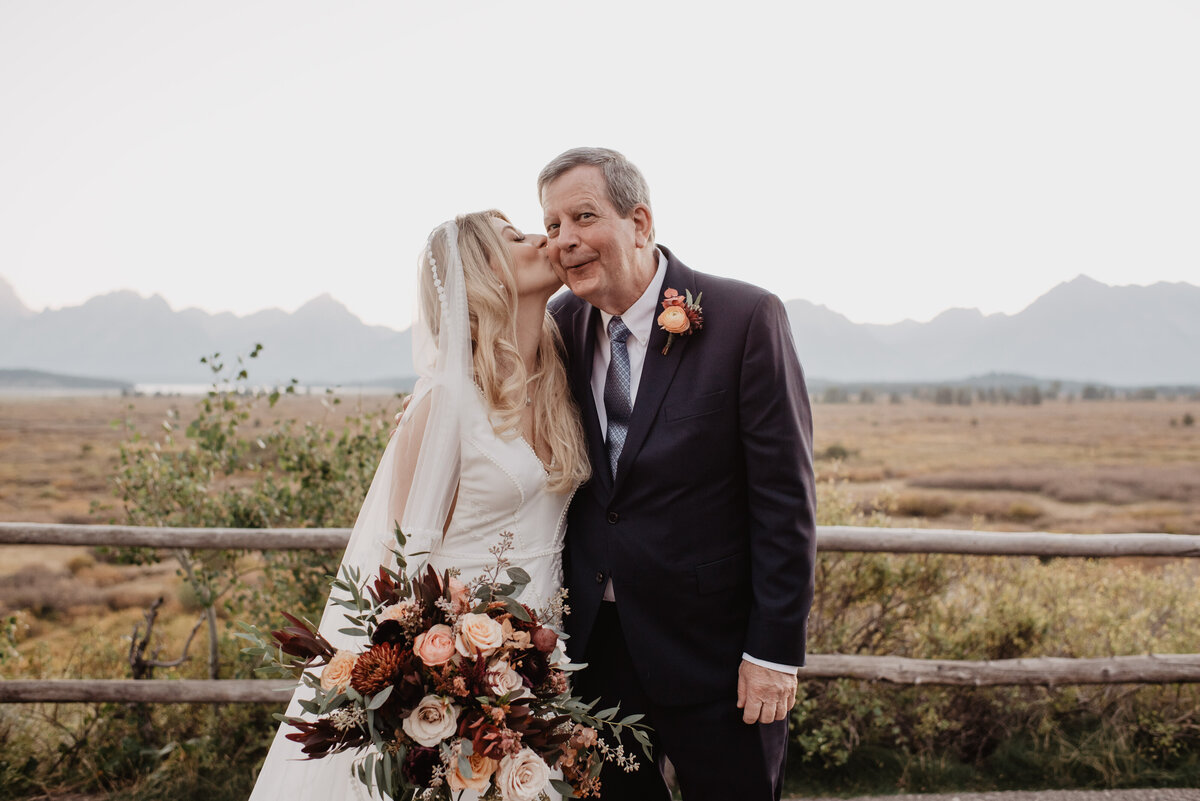 Photographers Jackson Hole capture bride kissing father's cheek