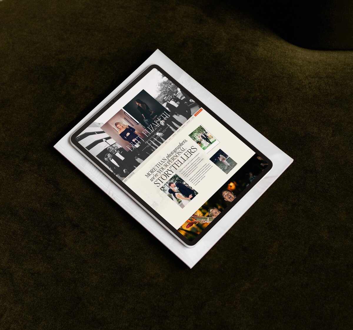 A tablet displaying a website for a photographer is placed on top of a white document, set against a dark green surface, reflecting the impact of personal branding for photographers.