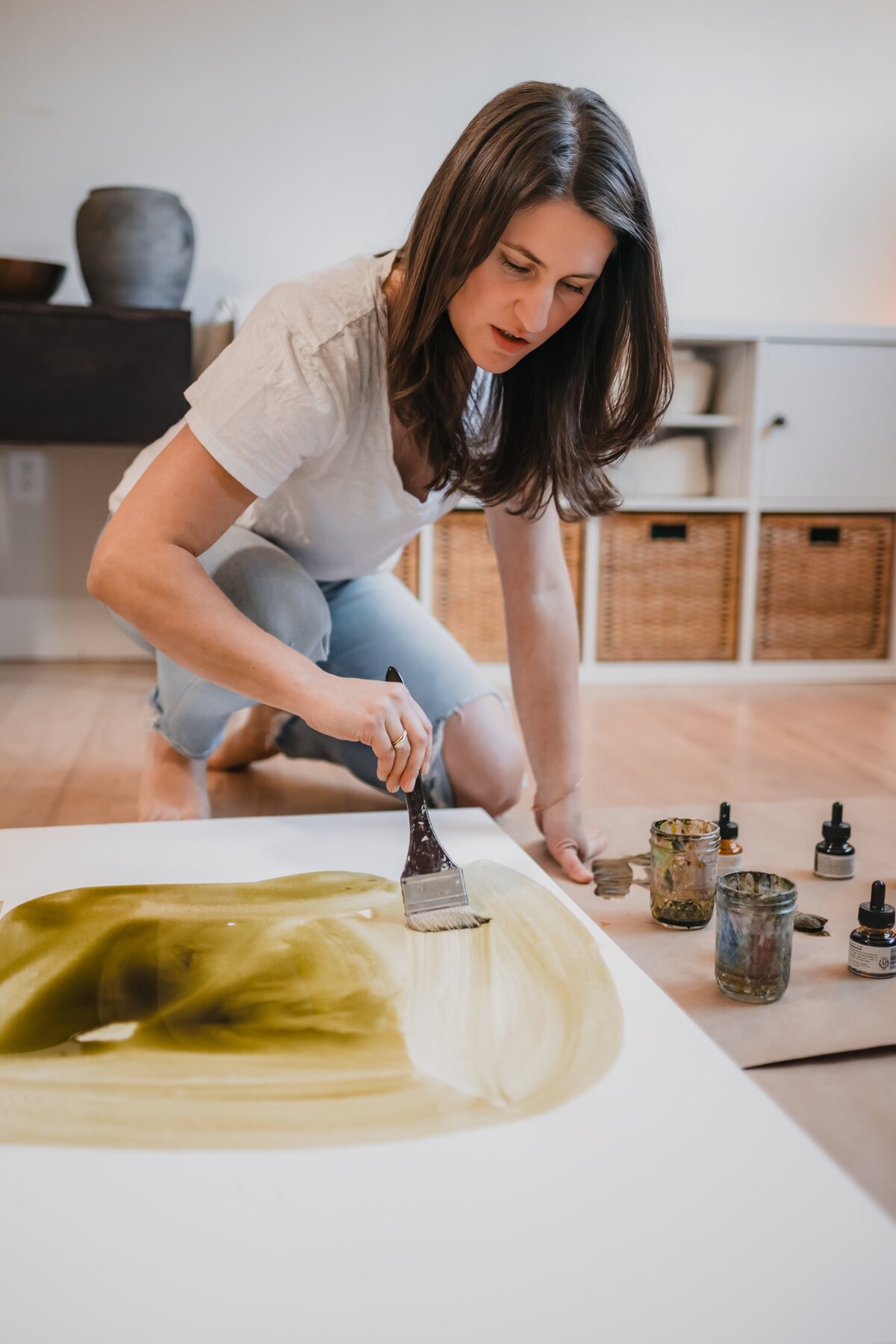 Texas artist painting on canvas in her home studio during personal branding session.
