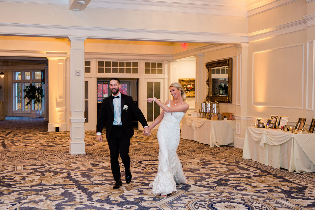 bride and groom entering wedding reception  best photographer Rixey Manor
