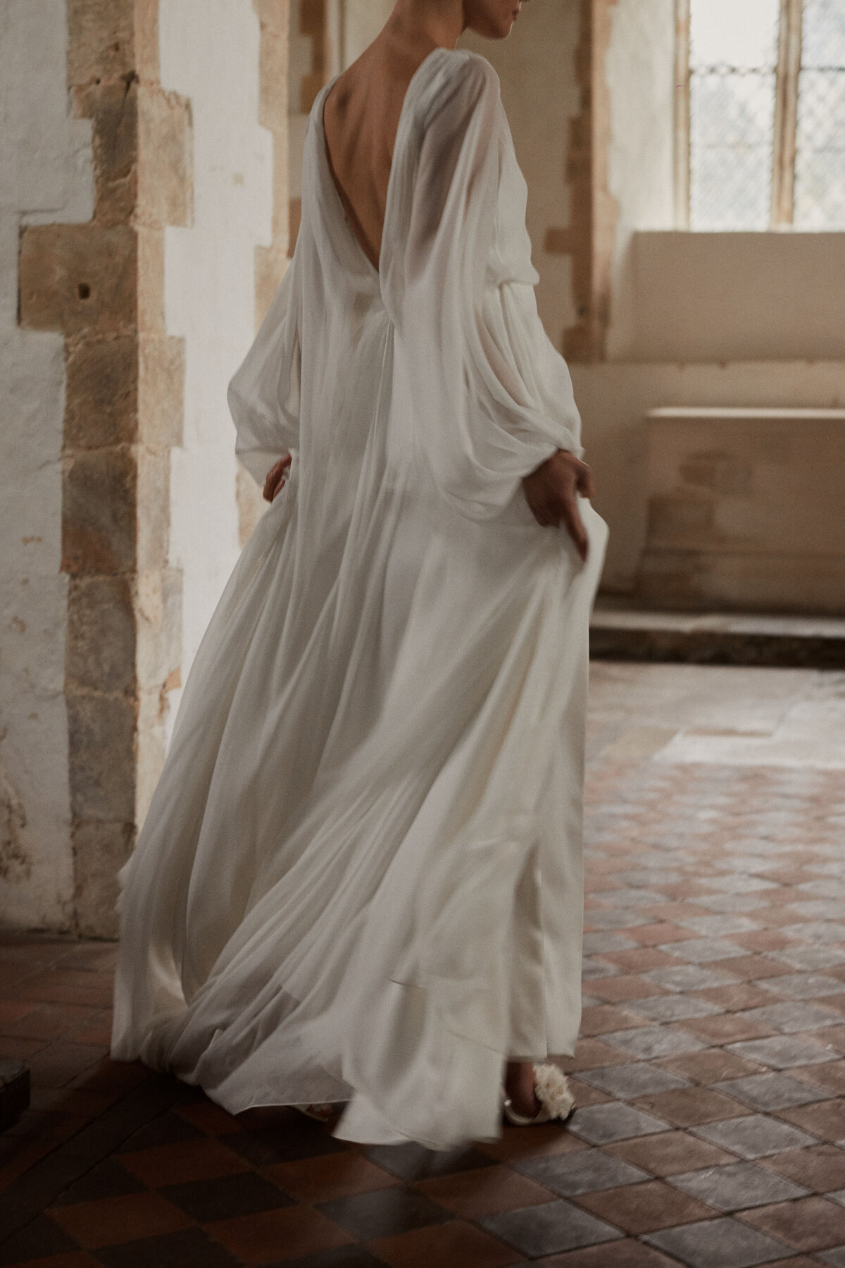 Bride wearing handmade british wedding dress in georgette silk, in church setting