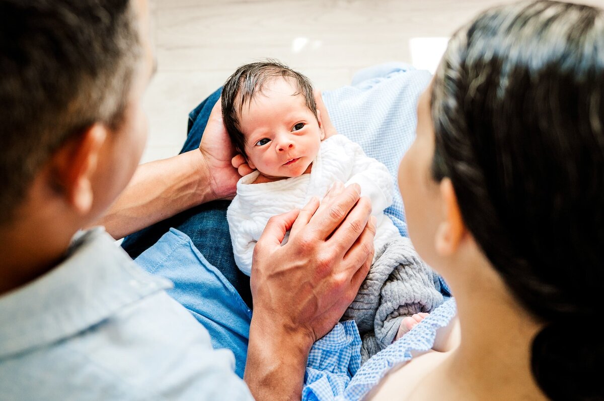 newborn baby boy looking at parents