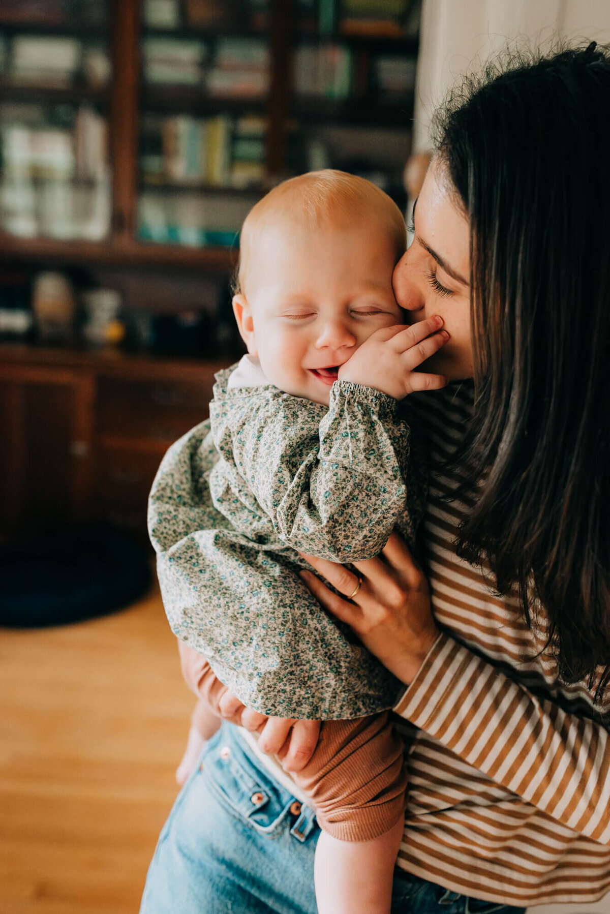A mother kisses her daughter on the cheek while